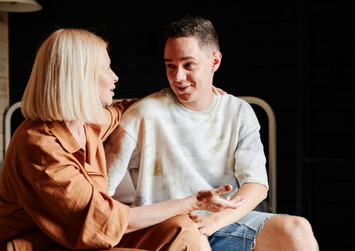 Eine Mutter und ihr Sohn sitzen nebeneinander und sprechen miteinander